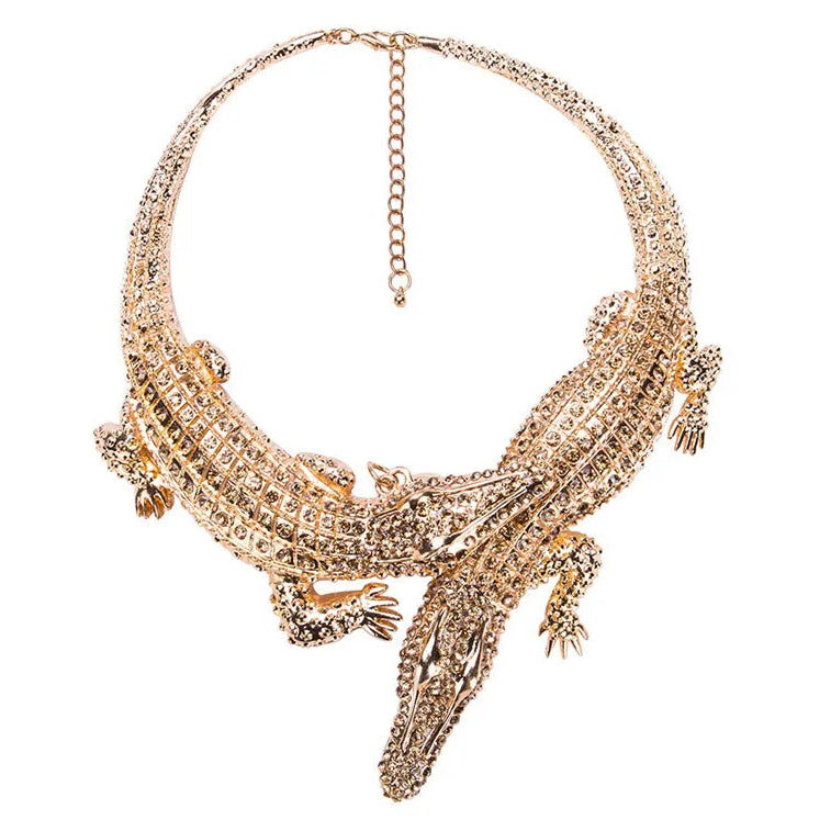 Gold crocodile-shaped necklace on a white background