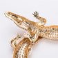 Gold lizard-shaped object on a white background