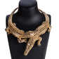 Gold crocodile-shaped necklace on a black mannequin