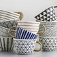 Set of ceramic mugs with geometric patterns on a light gray background