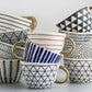 Set of ceramic mugs with geometric patterns on a light gray background