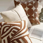 Decorative pillows on a couch with a Celine box and statue in the background