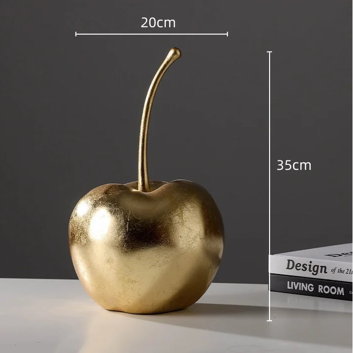 Gold cherry decorative item with measurements on a dark background