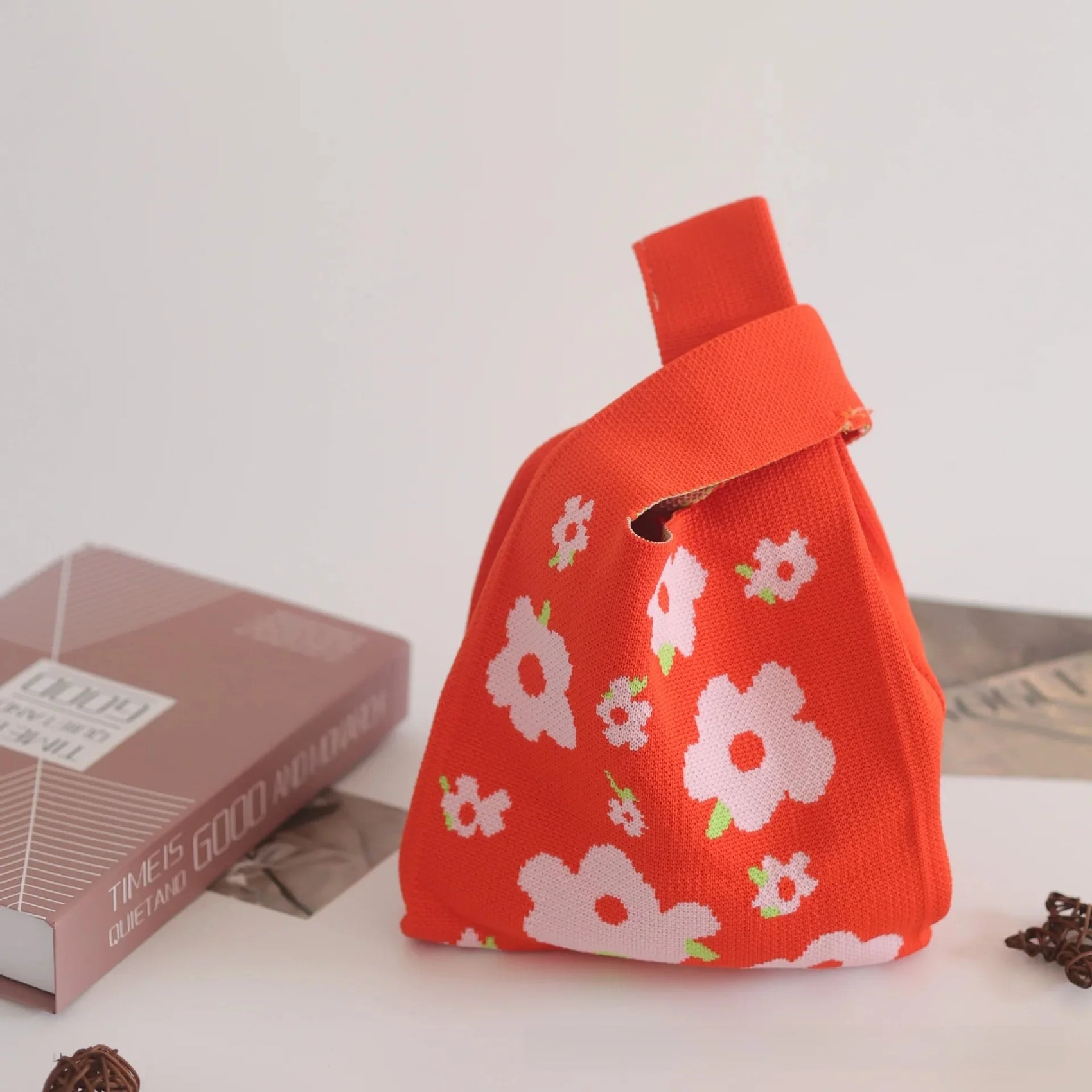 Red fabric bag with floral patterns on a light surface