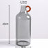 Clear glass bottle with a red handle, shown with measurements on a white background