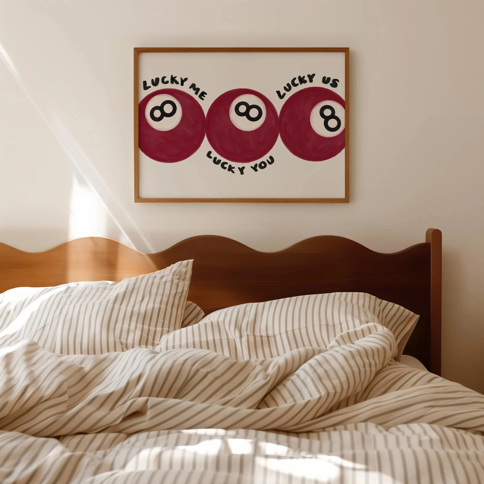 Bedroom with striped bedding and a framed artwork on the wall.