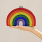 Rainbow-colored clutch held by a hand with 'CEZIRA' branding above.