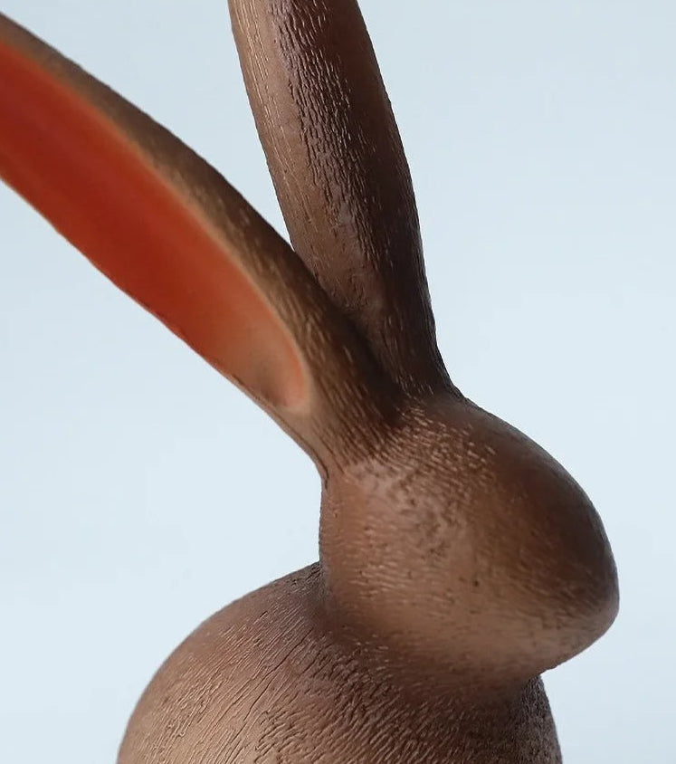 Close-up of a wooden rabbit figurine with a plain background