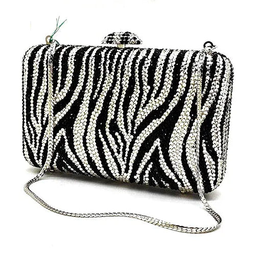 Black and white zebra patterned clutch bag with a chain strap on a white background