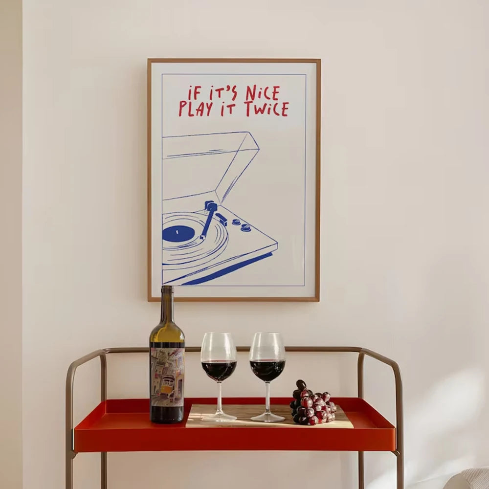 Framed artwork with a quote above a table with wine and grapes.