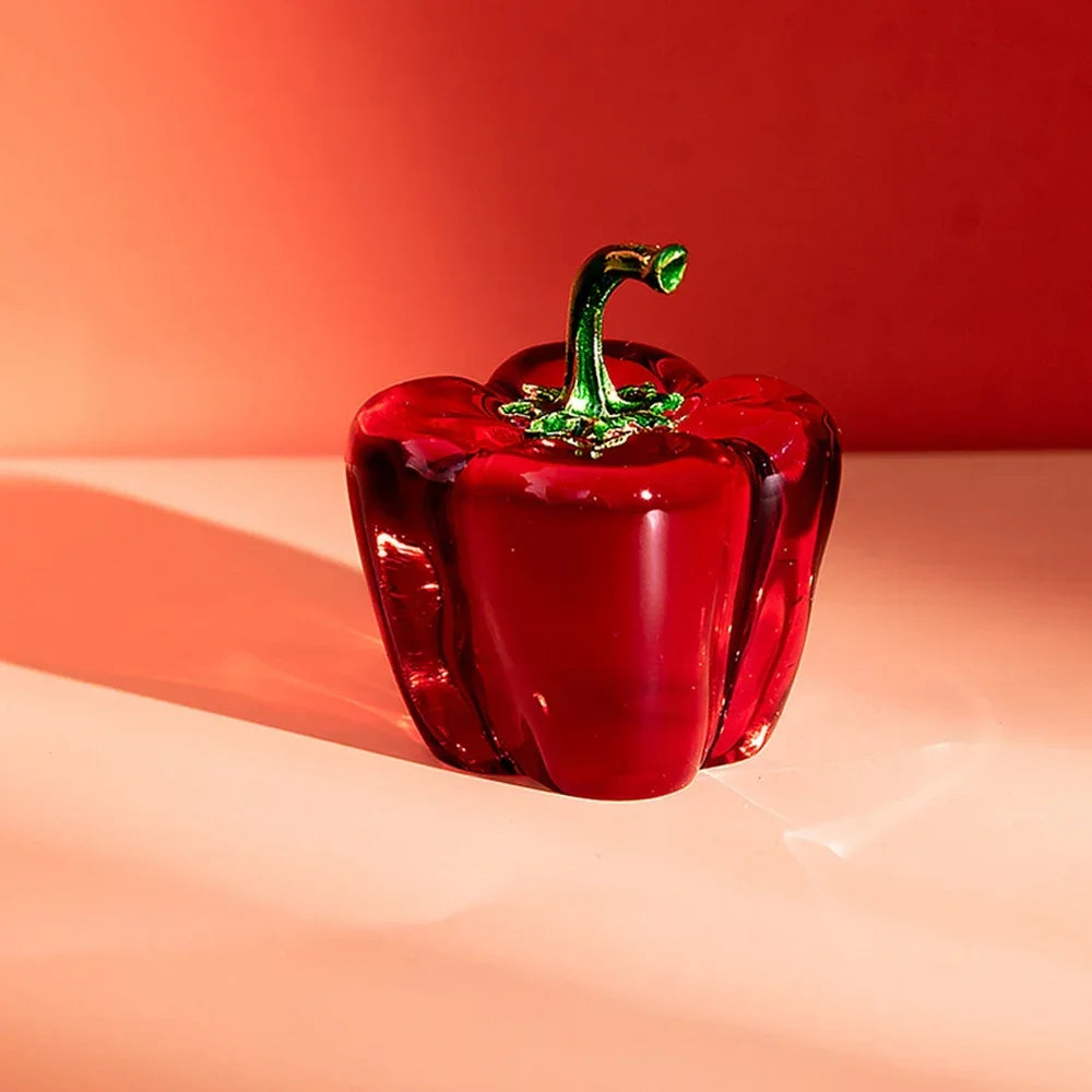 Red glass pepper on a peach surface with a red background