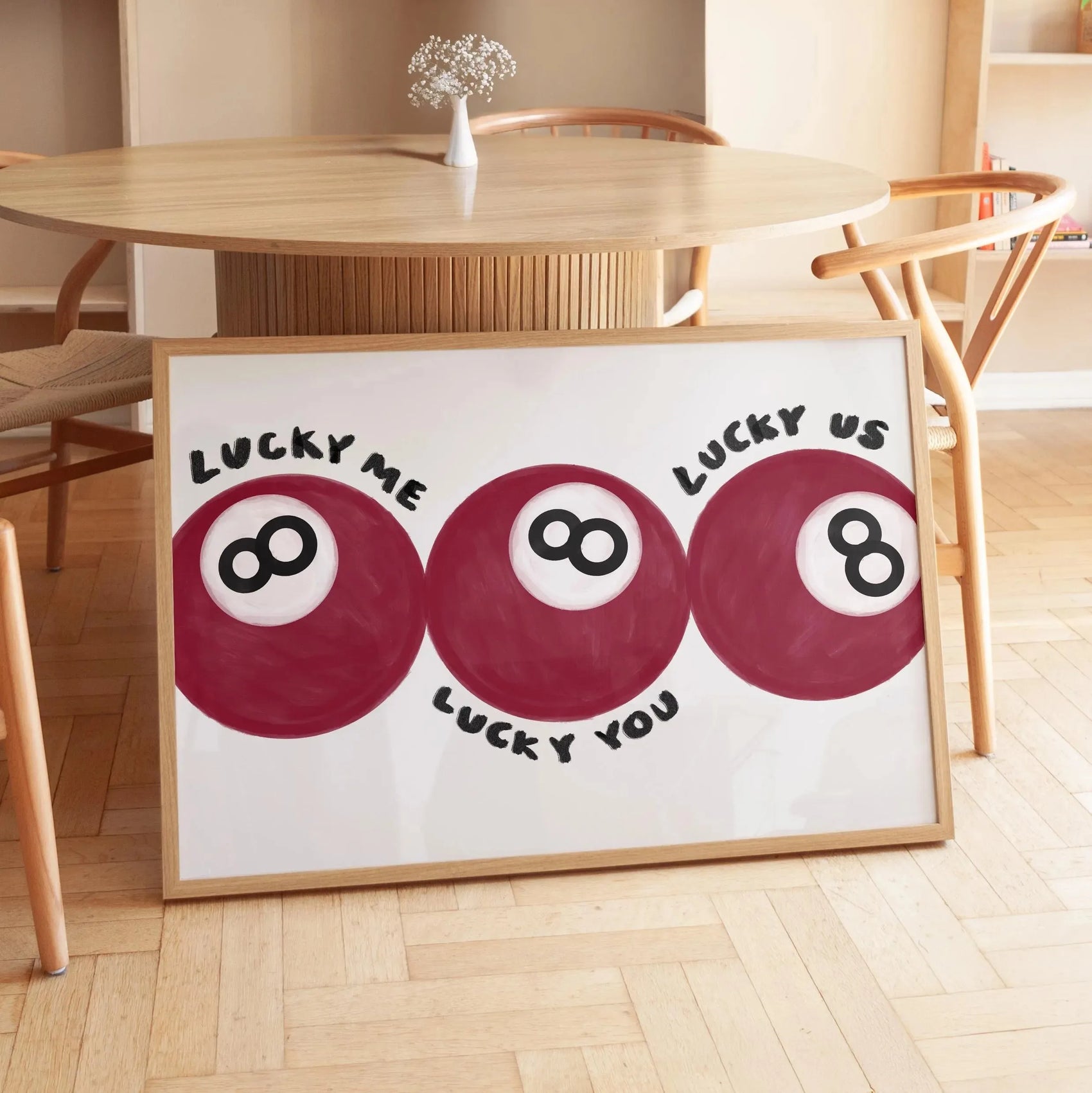 Framed artwork with red circles and text in a room with wooden furniture