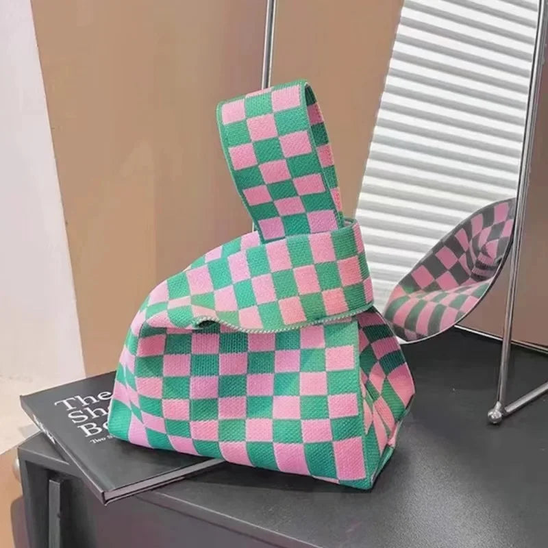 Checkered bag with pink and green pattern on a surface