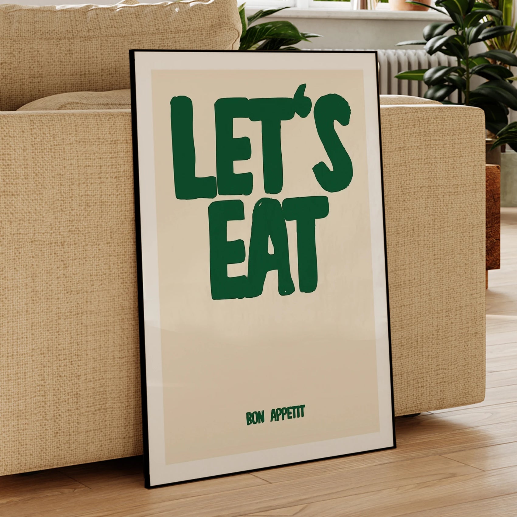 Framed poster with 'LET'S EAT' text in a living room setting