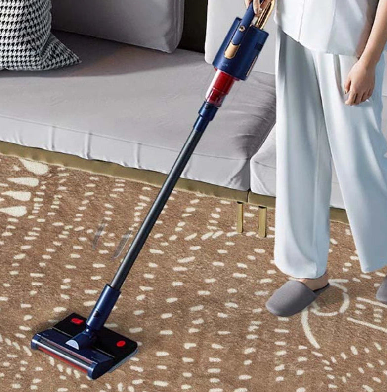 Person using a cordless vacuum cleaner on a patterned carpet