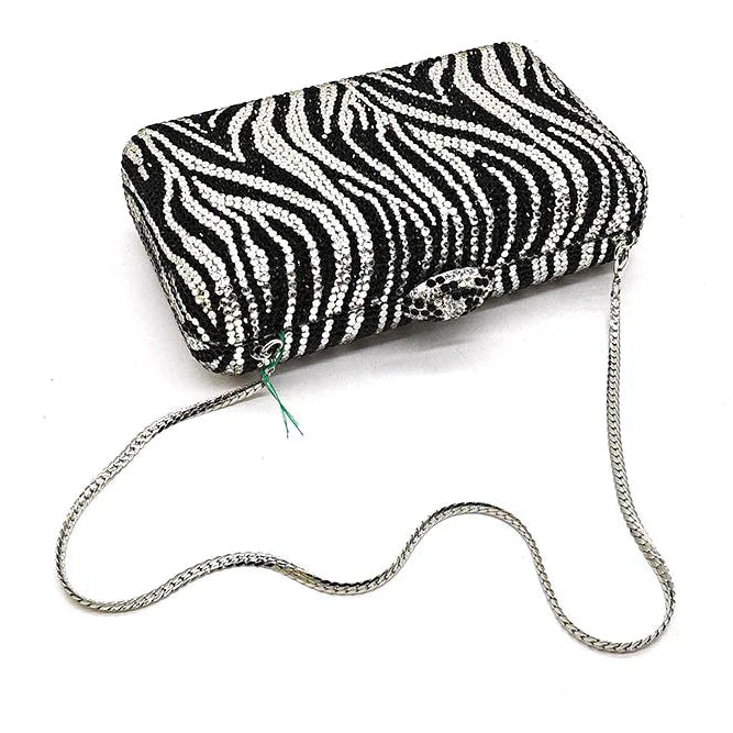 Black and white zebra-striped clutch bag with a chain strap on a white background