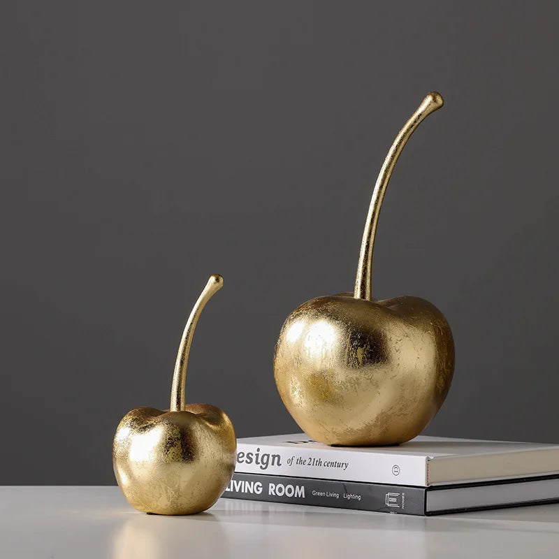 Two gold cherries on a stack of books with a dark gray background