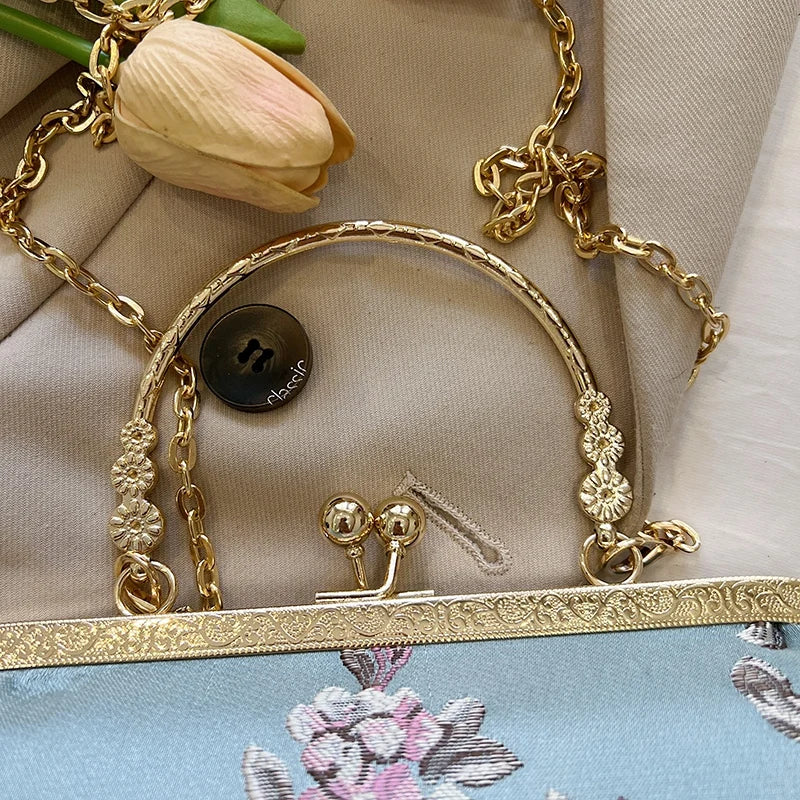 Gold jewelry set with a necklace, bracelet, and earrings on a floral fabric background.