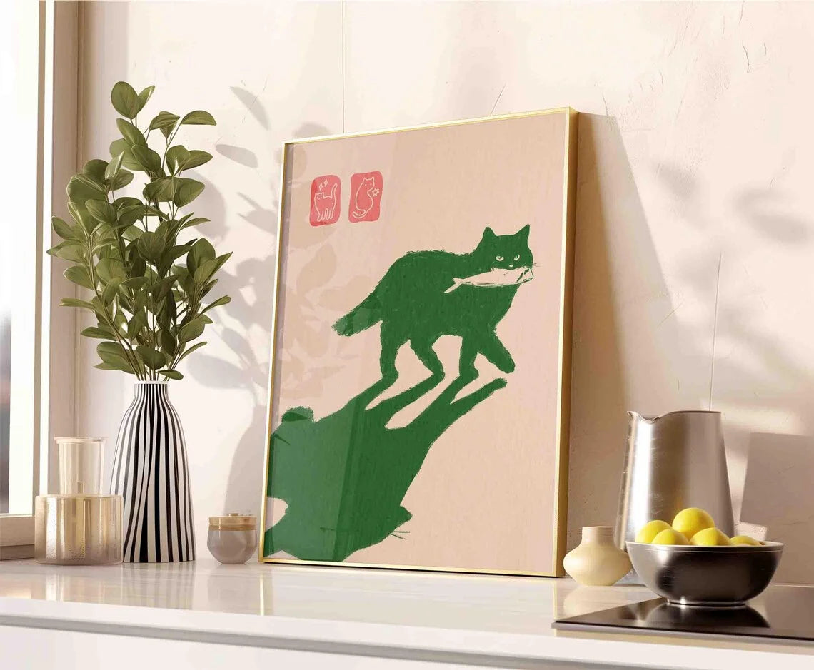 Framed artwork of a green cat on a beige background in a modern kitchen setting.