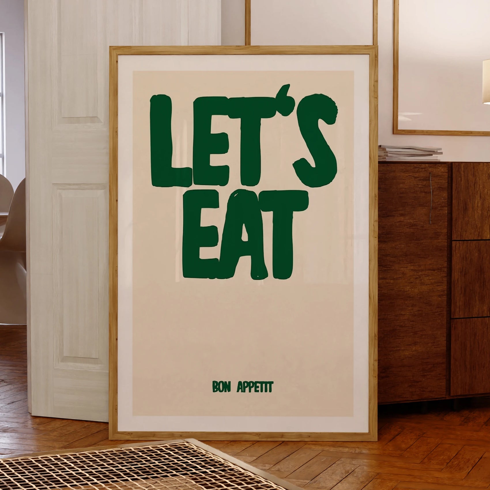 Framed poster with 'LET'S EAT' text in a home setting