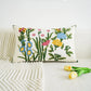Decorative pillow with floral embroidery on a white couch with tulips.