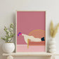 Framed abstract artwork of a reclining figure on a pink background, displayed on a shelf with decorative items.