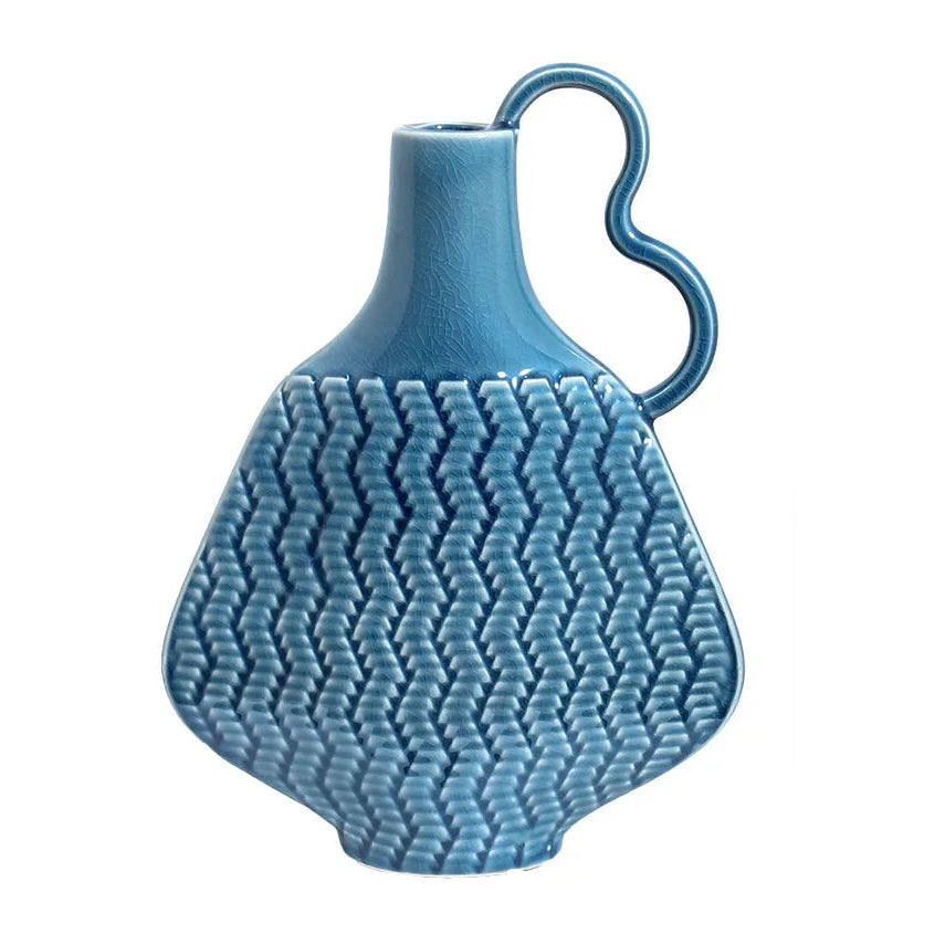A blue Instagram style vintage porcelain ceramic vase with a geometric pattern and a handle on the side.