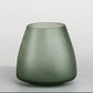 Green glass vase on a light gray background