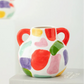 Colorful ceramic vase with abstract patterns on a white surface