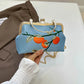 Handbag with floral design held by a hand on a neutral background