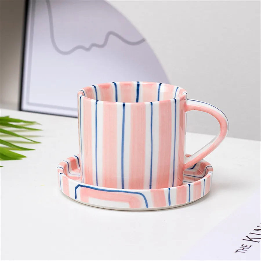 Striped ceramic mug and coaster set on a light surface with a blurred background