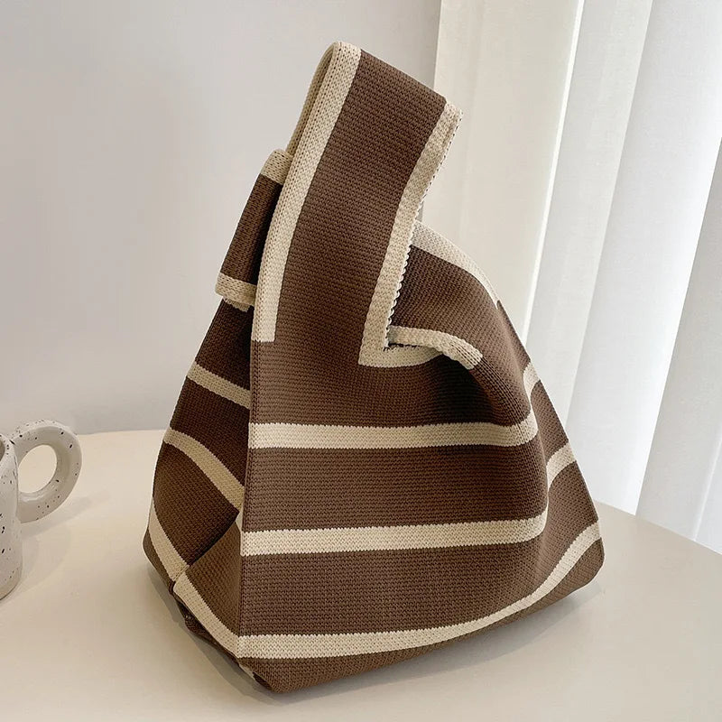 Brown and beige striped bag on a light surface with a neutral background