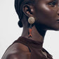 Close-up of a woman wearing a fish-shaped earring with a neutral background
