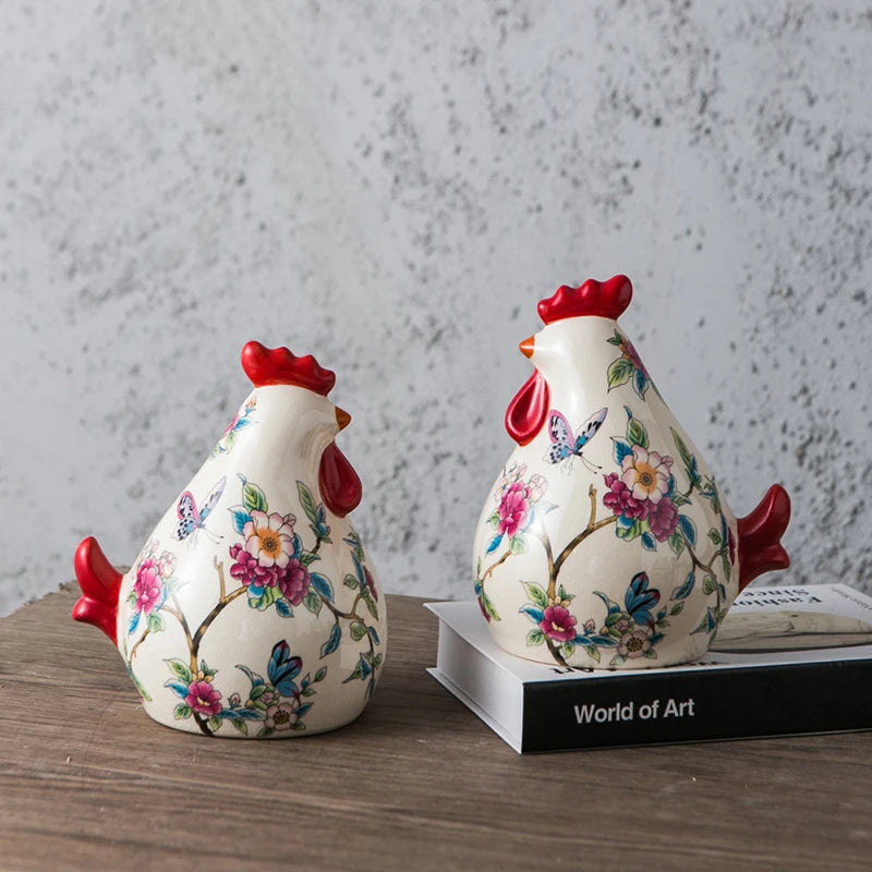 Two decorative ceramic rooster figurines with floral patterns on a wooden surface.
