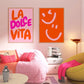 Modern bedroom with pink and orange wall art, a bed, and a green chair.
