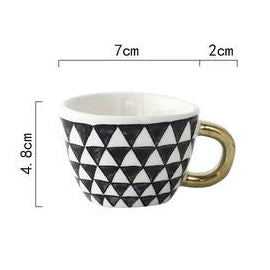Ceramic mug with black and white triangle pattern and gold handle, shown with measurements on a white background.