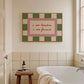 Bathroom with a bathtub, stool, and framed artwork on the wall.