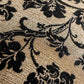 Close-up of a black floral pattern on a beige fabric surface