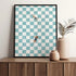 Framed checkered art print on a wooden shelf with decorative vases.