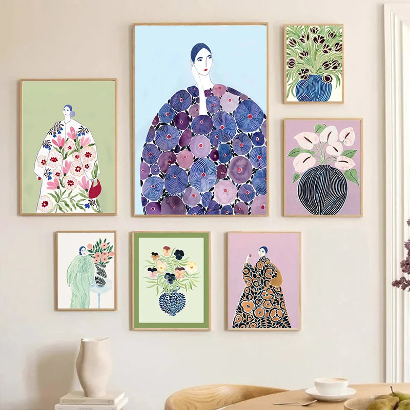 Set of framed artistic prints of women in floral dresses on a wall.