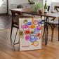 Colorful children's drawing of ice cream cones on a wooden floor in a room with a dining table and chairs.