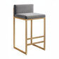 Bar stool with gray cushioned seat and gold metal frame on a white background