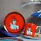 Ceramic mug and plate set with artistic design on a gray background