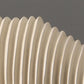 Close-up of a beige corrugated pipe against a dark background