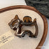 Metallic dog-shaped object on a wooden tray with a beige surface