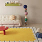 Modern living room with a yellow rug, white sofa, and colorful balloons.