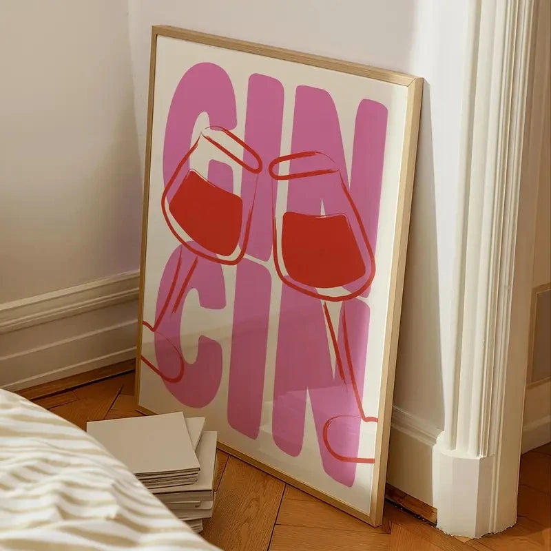 Framed artwork with 'GIN CHAI' text and red glasses on a white background, leaning against a wall.