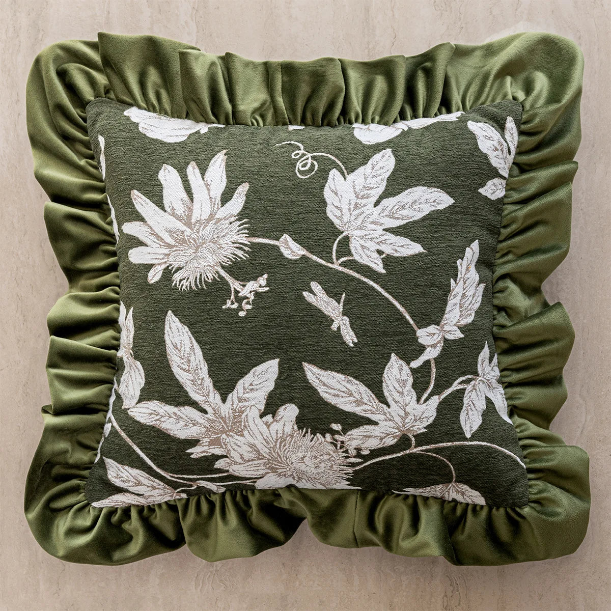 Decorative pillow with floral pattern and green ruffled edge on a beige background