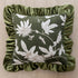 Decorative pillow with floral pattern and green ruffled edge on a beige background