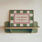 Decorative shelf with a framed checkered picture on a plain wall